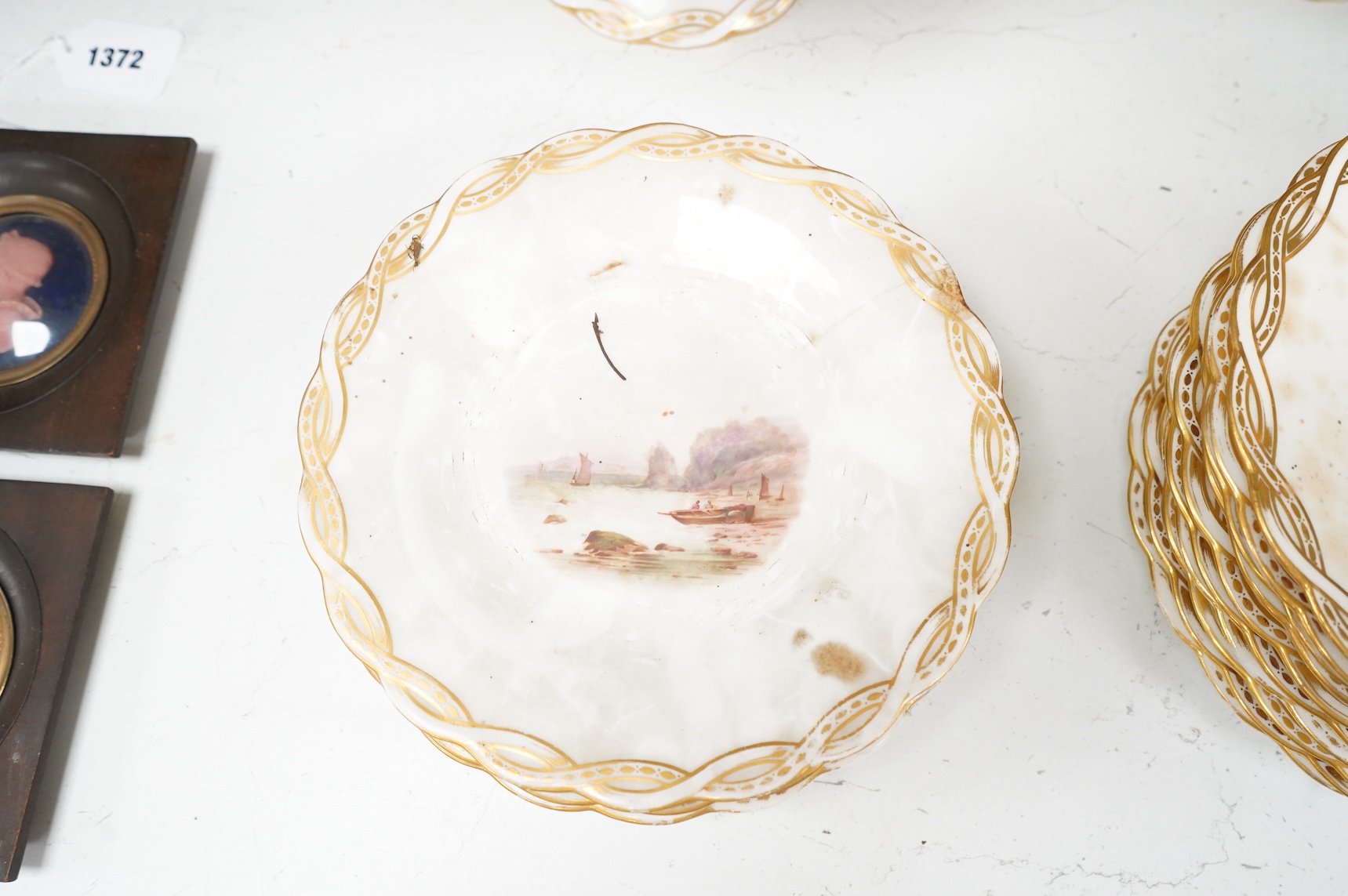 A Late 19th century Minton porcelain part dessert service, each piece painted with differing landscapes, largest 28cm in diameter